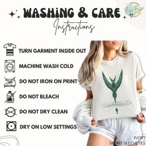 May include: Ivory short sleeve tee with a green bird graphic. The image also shows washing instructions: turn garment inside out, machine wash cold, do not iron on print, do not bleach, do not dry clean, and dry on low settings.