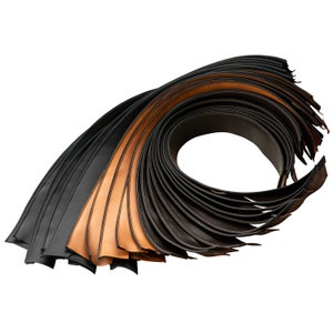 Könnte beinhalten: Ein Stapel Lederstreifen in Schwarz und Braun. Die Streifen sind spiralförmig aufgerollt.