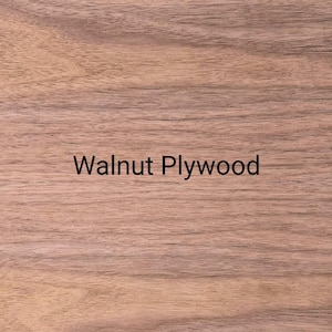 Puede incluir: Una l&aacute;mina rectangular y plana de madera contrachapada de nogal con un patr&oacute;n de veta natural de color marr&oacute;n claro y l&iacute;neas horizontales. El texto "Walnut Plywood" est&aacute; impreso en una fuente negra sencilla y sin remates en el centro.