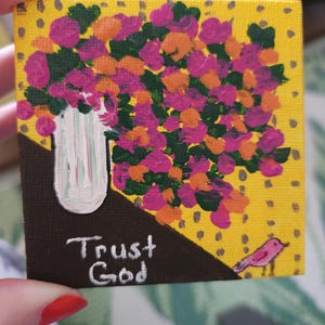 May include: Miniature square painting featuring a bouquet of pink and orange flowers in a white vase against a yellow dotted background. The painting includes the text "Trust God" and a small pink bird.