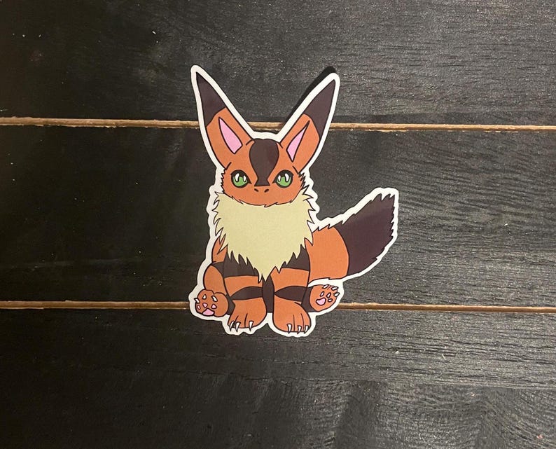 May include: A sticker of a cartoon fox with orange and brown fur, a white chest, and green eyes. The fox is sitting on its hind legs with its tail curled behind it.