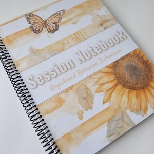 May include: A spiral-bound notebook with a white cover featuring yellow watercolor stripes, a butterfly illustration, and a large sunflower. The text reads Session Notebook and Registered Behavior Technician in a white, bold, sans-serif font.