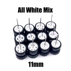 May include: A set of 12 white 11mm wheels for model cars. The wheels are made of plastic and have a black tire. The wheels are arranged in a circle with a nail through each one.