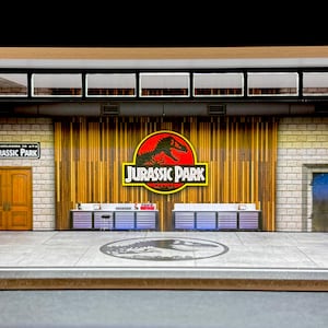 May include: A model of the Jurassic Park visitor centre entrance with a brown wooden door, a brick wall, and a sign that reads "Jurassic Park".