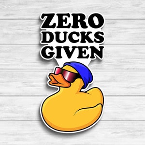 May include: A yellow rubber duck wearing sunglasses and a blue hat with the text "ZERO DUCKS GIVEN" above it.