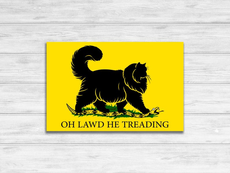 May include: A yellow flag featuring a black cat walking on a green snake. The text "OH LAWD HE TREADING" is printed below the cat.