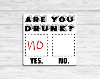 May include: A white sign with black text that reads "Are you drunk?" with two boxes below. The box on the left says "Yes." and the box on the right says "No." The box on the left has a red "no" written inside.