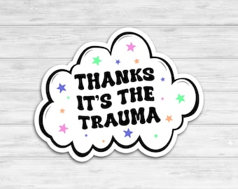 May include: White cloud-shaped sticker with a black outline and the text "THANKS IT'S THE TRAUMA" in black. The sticker is decorated with colorful stars.