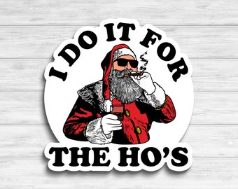May include: A white sticker with a red and white illustration of Santa Claus wearing sunglasses and smoking a cigar. The text "I do it for the ho's" is printed in black on the sticker.