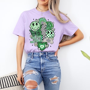 May include: A lavender t-shirt with a green and white graphic design featuring smiley faces, butterflies, and the text "Cerebral Palsy Awareness".