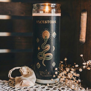 “Black ancestor ritual candle burning in rustic setting with lace cloth, dried flowers, and fabric pouch, spiritual meditation candle for ancestral veneration and home altar décor.”