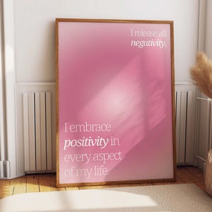 May include: A pink and white motivational poster with the text "I embrace positivity in every aspect of my life. I release all negativity."
