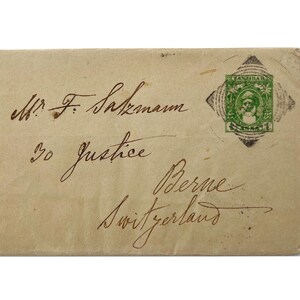 May include: A vintage envelope addressed to Mr. F. Salzmann, Justice, Berne, Switzerland. The envelope has a green stamp with a portrait of a man.