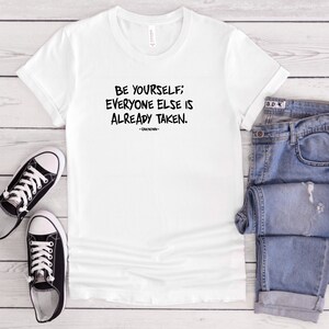 Puede incluir: Camiseta blanca con texto negro que dice "Sé tú mismo; todos los demás ya están cogidos."  -Desconocido-