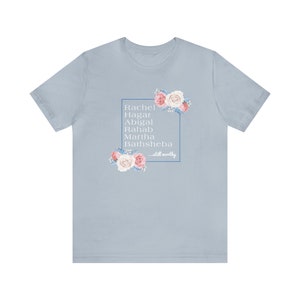 May include: Light blue t-shirt with a floral design and the text "Rachel, Hagar, Abigail, Rahab, Martha, Bathsheba...still worthy" in a white box.