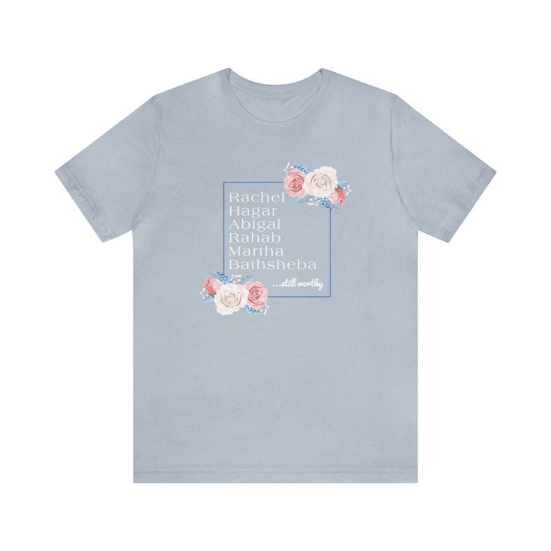 May include: Light blue t-shirt with a floral design and the text "Rachel, Hagar, Abigail, Rahab, Martha, Bathsheba...still worthy" in a white box.
