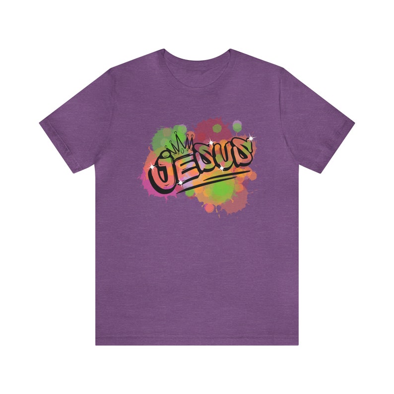 May include: Purple t-shirt with a colorful watercolor design of the word "JESUS" with a crown above the "J".