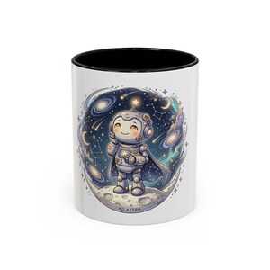 Peut inclure: Un mug en céramique blanche avec un intérieur et un bord noirs, orné d'un dessin de petit robot debout sur un croissant de lune. Le robot porte une cape et est entouré d'une scène spatiale bleu foncé avec des étoiles, des galaxies et le texte AD ASTRA.