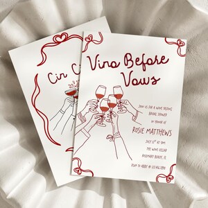 May include: Two white cards with red text and illustrations. The cards read "Vina Before Vows" and "Cir C". The illustrations depict hands toasting with wine glasses. The cards are for a wine tasting bridal shower.