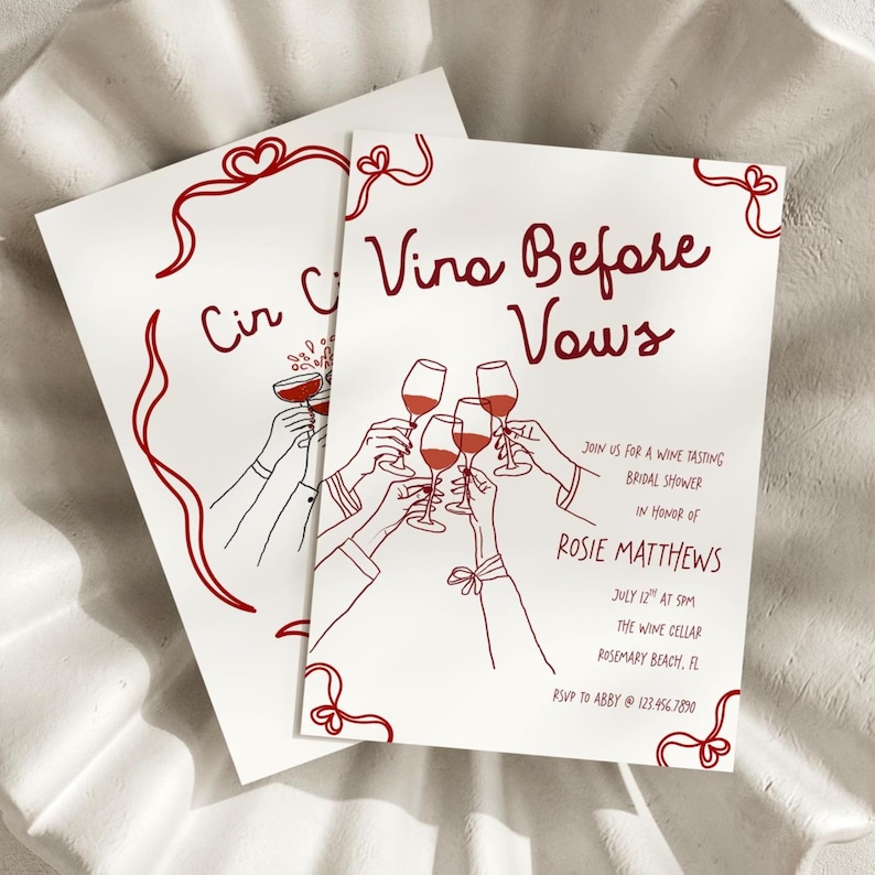 May include: Two white cards with red text and illustrations. The cards read "Vina Before Vows" and "Cir C". The illustrations depict hands toasting with wine glasses. The cards are for a wine tasting bridal shower.