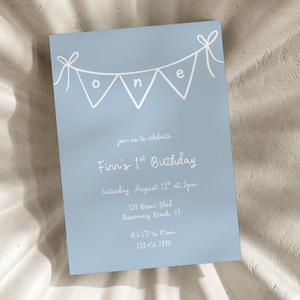 May include: A pale blue birthday invitation with white text and a banner spelling "ONE". The invitation reads "join us to celebrate Finn's 1st Birthday" and includes the date, time, and address.