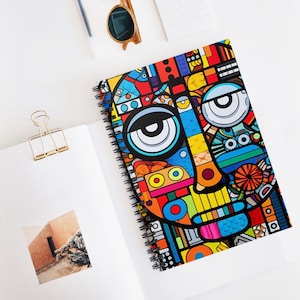 Peut inclure: Un carnet à spirales coloré avec un motif géométrique représentant un visage avec de grands yeux, un nez et une bouche. Le motif est composé de différentes formes et couleurs, notamment le rouge, le bleu, le jaune, le vert et le noir.