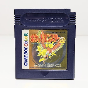 Op de afbeelding: Een blauwe Game Boy Color-cartridge met een gouden label waarop een Japans Pok&eacute;mon-personage, de tekst "Pocket Monsters Gold" en de tekst "Game Boy & Color Gemeenschappelijk" te zien zijn.