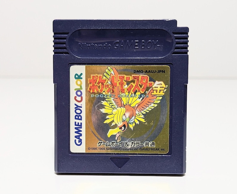 Op de afbeelding: Een blauwe Game Boy Color-cartridge met een gouden label waarop een Japans Pok&eacute;mon-personage, de tekst "Pocket Monsters Gold" en de tekst "Game Boy & Color Gemeenschappelijk" te zien zijn.