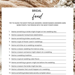 May include: A white paper game titled "Bridal Feud" with a list of questions about weddings. The game is decorated with dried flowers and text that reads "Try to guess the most popular answers. Higher ranked answers earn more points."
