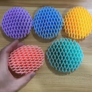 May include: Four colorful, round, textured, decorative items. The items are made of a plastic-like material and have a grid pattern. The colors are purple, blue, orange, and light blue.