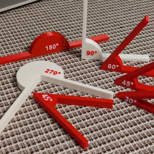 May include: A collection of red and white plastic protractors, each labeled with degree measurements. Angles include 30, 45, 60, 90, 180, and 270 degrees. The protractors are arranged on a patterned surface.