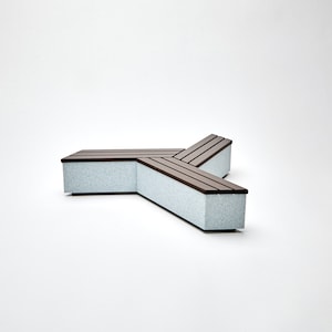 May include: A three-sided concrete bench with a brown wooden slat top. The bench is shaped like a Y and has a light gray speckled finish.