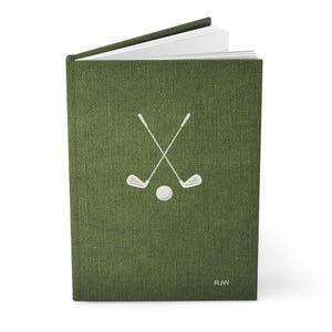 K&ouml;nnte beinhalten: Ein gr&uuml;nes Leinen-Notizbuch mit einem wei&szlig;en Golfclub- und Ball-Design. Das Notizbuch tr&auml;gt die Initialen "RJW" in der unteren rechten Ecke.