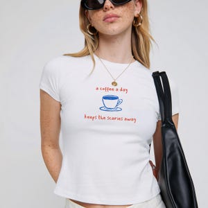 A Coffee a Day Keeps the Scaries Away Baby Tee, Cute Fitted Graphic Tee for Coffee Lovers, Soft Girl Aesthetic Shirt, Y2K Coffee Shirt