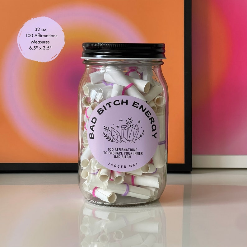 Smaller sized Bad Bitch Energy affirmations jar in front of brightly colored poster prints.