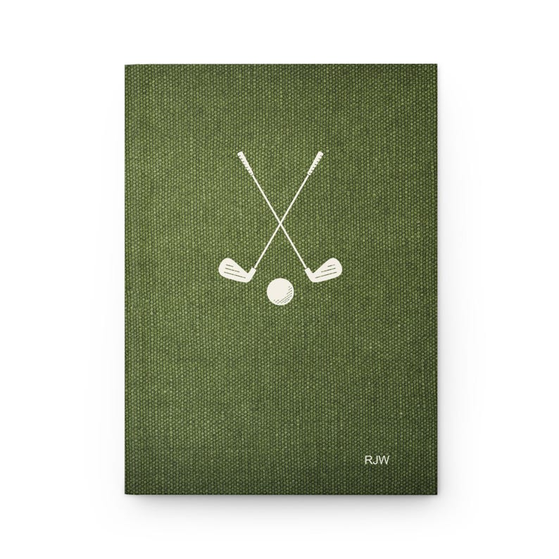 K&ouml;nnte beinhalten: Ein gr&uuml;nes Notizbuch aus Canvas mit einem wei&szlig;en Design aus gekreuzten Golfschl&auml;gern und einem Ball. Das Notizbuch tr&auml;gt die Initialen "RJW" in der unteren rechten Ecke.