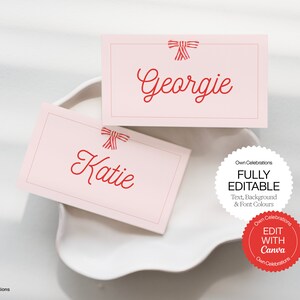 May include: Two pink place cards with red bows and the names "Katie" and "Georgie" written in red cursive. The text "FULLY EDITABLE Text, Background & Font Colours" and a red circle with the text "EDIT WITH Canva" are visible below the place cards.