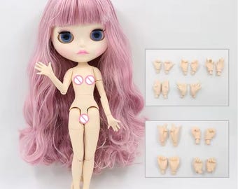 May include: A doll with long wavy pink hair, large blue eyes, and pale skin. The doll has articulated joints and is accompanied by two rectangular sets of interchangeable hand pieces in various poses, including open palms, fists, and finger gestures.