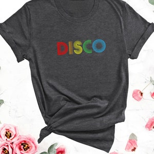May include: A dark grey t-shirt with the word "DISCO" printed in rainbow colors.