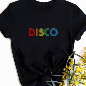 May include: Black t-shirt with the word "DISCO" in rainbow colors. The letters are made of stacked circles.