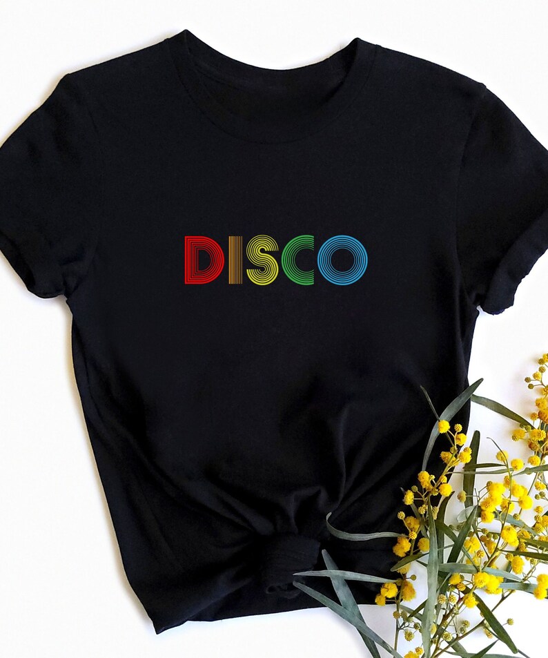 May include: Black t-shirt with the word "DISCO" in rainbow colors. The letters are made of stacked circles.