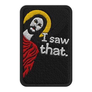 Op de afbeelding: Geborduurde patch met een afbeelding van Jezus met een gele halo, rode mantel en de tekst "I saw that." De patch heeft een zwarte achtergrond en een rechthoekige vorm met afgeronde hoeken.