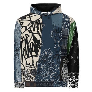 Könnte beinhalten: Ein langärmeliger Kapuzenpullover mit einem Patchwork-Design aus verschiedenen Bandana-Mustern in Blau-, Schwarz-, Weiß- und Grüntönen. Die Vorderseite zeigt kräftige schwarze Graffiti-Schriftzüge auf cremefarbenem Grund mit einer Tasche.