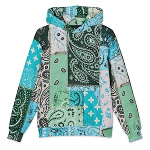 Op de afbeelding: Een sweatshirt met lange mouwen en capuchon met een patchworkontwerp van diverse bandana-patronen in tinten donkergroen, lichtgroen, turquoise en wit. Het kledingstuk is voorzien van een kangoeroezak aan de voorzijde en een capuchon zonder trekkoord.