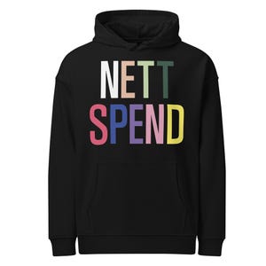 May include: Black hoodie with the text "NETT SPEND" in colorful block letters. The word "NETT" is in white, peach, and green. The word "SPEND" is in pink, blue, purple, and yellow. The hoodie has a front pocket and a hood.