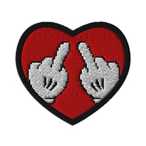 Può includere: Toppa ricamata con un cuore rosso e bordo nero. All'interno del cuore ci sono due mani guantate bianche che fanno il dito medio. La toppa è progettata per essere applicata su abbigliamento o accessori.