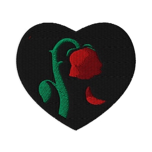 May include: Embroidered heart-shaped patch with a red rose, green stem and leaves on a black background. The rose is drooping, with a single petal falling. Ideal for clothing or accessories.