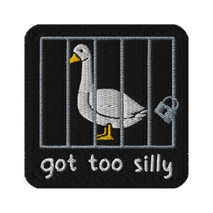 May include: Embroidered patch featuring a white goose inside a cage with a silver padlock. The goose has a yellow beak and feet. The text "got too silly" is embroidered in white below the cage on a black background.