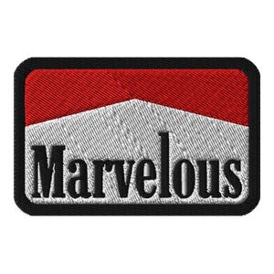 Peut inclure: Écusson brodé avec un motif rouge et blanc et le mot "Marvelous" en lettres noires. L'écusson a une bordure noire et un aspect texturé.