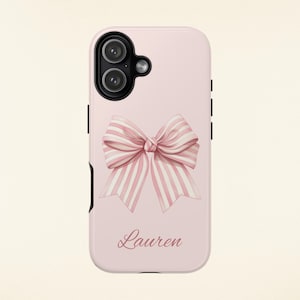 Op de afbeelding: Lichtroze telefoonhoesje met een aquarel strik met roze en witte strepen. De naam "Lauren" staat in cursief onder de strik. De hoes heeft een zwarte camera-uitsparing en zwarte zijknoppen.